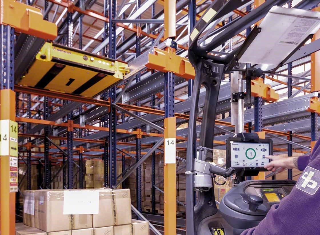 Un operario controla el carro Pallet Shuttle semiautomático desde el autoelevador Un operario controla el carro Pallet Shuttle semiautomático desde el autoelevador