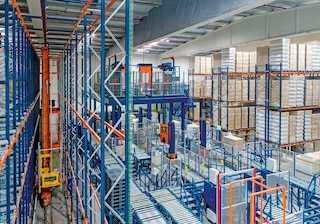 Distintos sistemas automáticos funcionando en un almacén robotizado